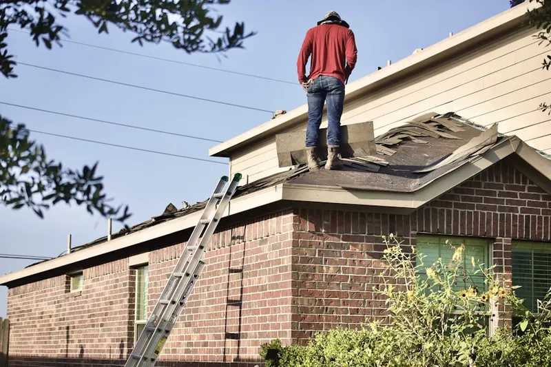Professional roofer working on a residential roof in Browning